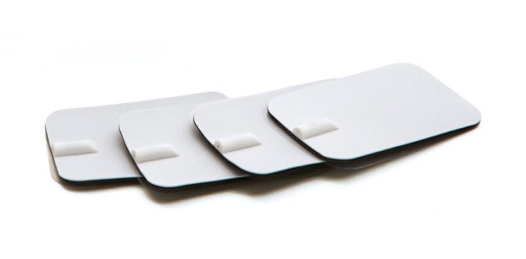 Set van 4 witte Circulation Maxx electro TENS pads met aansluitpunt voor kabels op witte achtergrond.